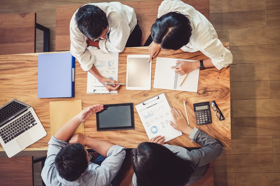 Equipo de trabajo revisando documentos y planos sobre una mesa